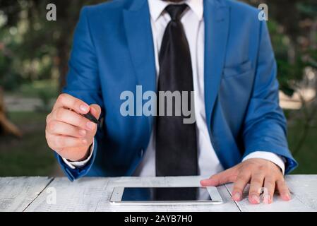 Homme d'affaires tient le stylo et pointe dans l'espace de copie. Homme avec le dessus de tour et le stylo dans la main. Concept d'affaires avec homme dans la suite W Banque D'Images