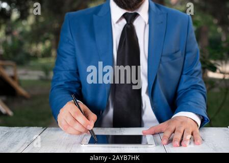 Homme d'affaires tient le stylo et pointe dans l'espace de copie. Homme avec le dessus de tour et le stylo dans la main. Concept d'affaires avec homme dans la suite W Banque D'Images