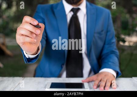 Homme d'affaires tient le stylo et pointe dans l'espace de copie. Homme avec le dessus de tour et le stylo dans la main. Concept d'affaires avec homme dans la suite W Banque D'Images