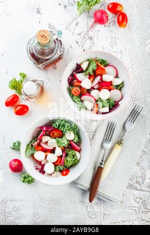 Salade avec tomates cerises, mozzarella et radsh, mélange de laitue Banque D'Images