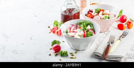 Salade avec tomates cerises, mozzarella et radsh, mélange de laitue Banque D'Images