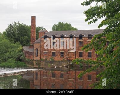 thwaite mill leeds construit en 1825 sur une île entre la rivière aire et le canal de navigation calder reflété dans l'eau et surr Banque D'Images