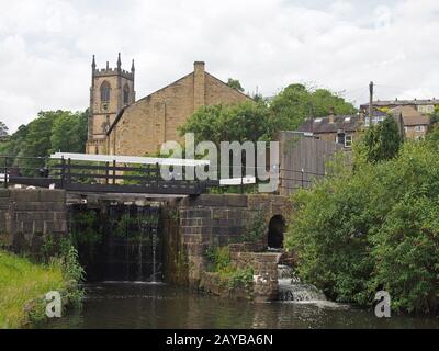 verrouillez les portes sur le canal du pont sowerby dans le yorkshire de l'ouest avec l'église historique christ entourée d'arbres Banque D'Images