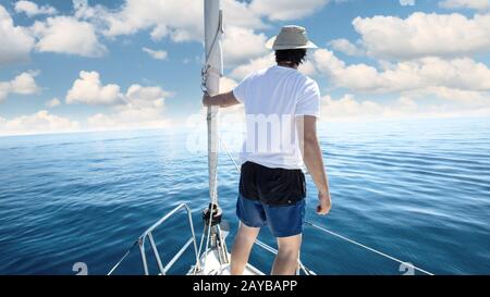 Homme debout à la proue d'un navire. Yachting, locations et la liberté concept. Banque D'Images