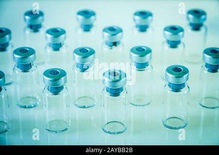 Flacons en verre de vaccin sur fond bleu Banque D'Images