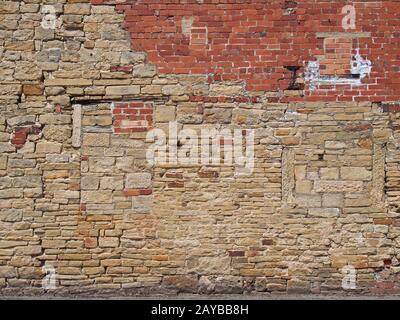 vieux mur extérieur avec un irrégulier patché et réparé de la brique et de la surface de pierre Banque D'Images