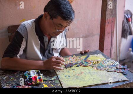 Un homme est la peinture traditionnelle javanais wayang kulit (marionnette d'ombre) faite de cuir à Yogyakarta, Java, Indonésie. Banque D'Images