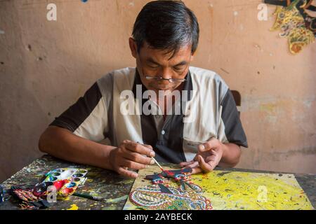 Un homme est la peinture traditionnelle javanais wayang kulit (marionnette d'ombre) faite de cuir à Yogyakarta, Java, Indonésie. Banque D'Images