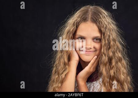 Closeup portrait of a cheerful dix ans, fille sur fond noir Banque D'Images