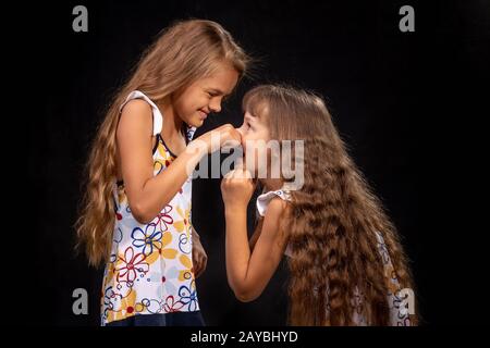 Une pincée de fille main sur le nez d'une autre fille Banque D'Images