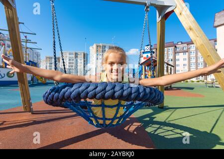 Girl joyeusement ses bras tout en circonscription répartis sur un cycle de rotation de suspension Banque D'Images