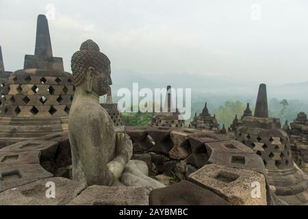 Statue de Bouddha sur une plate-forme supérieure du temple de Borobudur (site classé au patrimoine mondial de l'UNESCO, neuvième siècle), le plus grand temple bouddhiste au monde, à Mag Banque D'Images