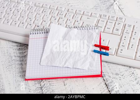 Bloc-notes en papier carré avec une note vide en forme de rectangle ci-dessus épinglée par deux clous de giropage sur la feuille. Clavier blanc sous a c Banque D'Images