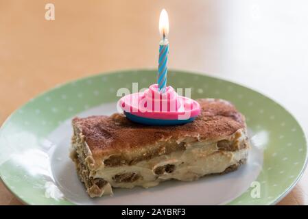 Bougie brûlante sur des crevettes à tarte tiramisu à l'anniversaire des enfants Banque D'Images