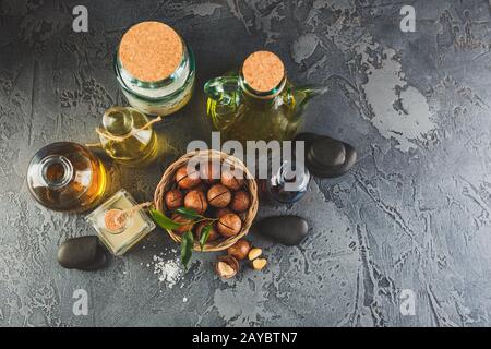 Huile macadamia naturelle dans une bouteille en verre avec noix de macadamia Banque D'Images