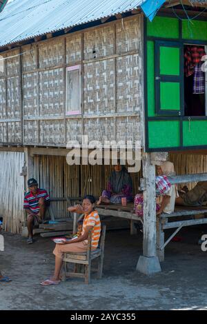 Une scène de village avec des gens à leur maison traditionnelle sur pilotis dans le petit village de Moyo Labuon sur l'île de Moyo, au large de la côte de l'île de Sumbawa, Banque D'Images