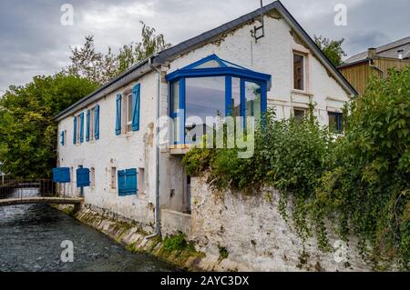 Ancienne maison le long de la rivière de ton avec volets bleus dans la ville Banque D'Images