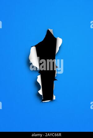 Papier déchiré bleu avec trou noir Banque D'Images