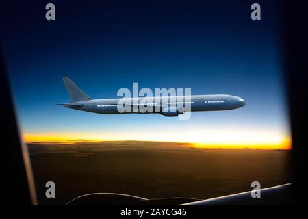 Vol d'un avion au-dessus des nuages au coucher du soleil . Banque D'Images