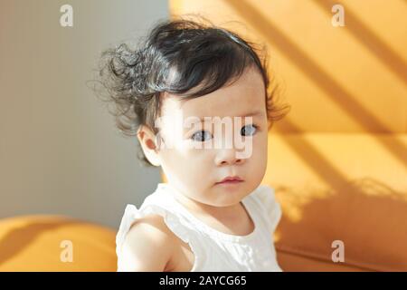 Portrait of cute et cheveux bouclés charmant bébé fille chinoise asiatique .