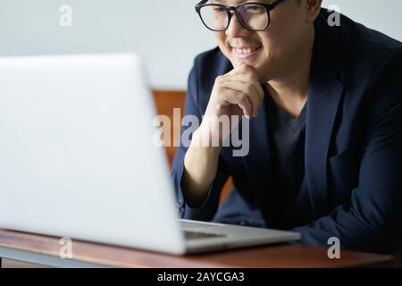 Homme d'affaires réussi sourire devant l'ordinateur Banque D'Images
