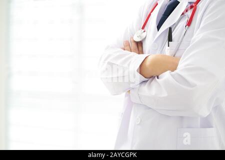 Médecin inconscient posant avec les bras croisés dans le bureau Banque D'Images
