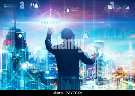 Vue arrière d'un homme d'affaires touchant le mot BIG DATA sur l'écran virtuel numérique avec les deux mains. Concept d'affaires high-tech . Banque D'Images