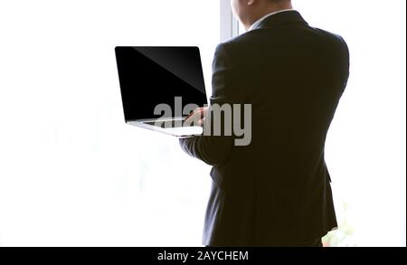 Vue arrière d'un jeune homme d'affaires travaillant sur un ordinateur portable Banque D'Images