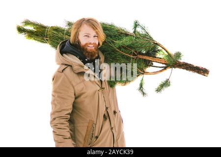 Le thème est le symbole des fêtes de Noël et du nouvel an. Un jeune homme caucasien avec une barbe porte un arbre de Noël Banque D'Images