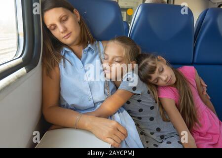 Maman et ses deux filles s'endormi dans un train électrique voiture Banque D'Images