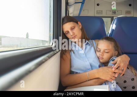 Mom and daughter hugging dormir dans un train voiture Banque D'Images