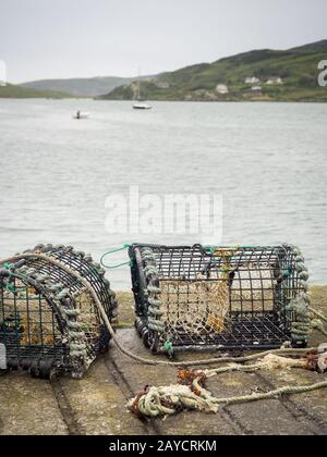 Casiers de crabe sur la baie de la jetée et bateaux en arrière-plan Banque D'Images