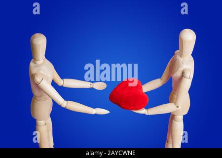 Figurines en bois avec coeur sur bleu Banque D'Images