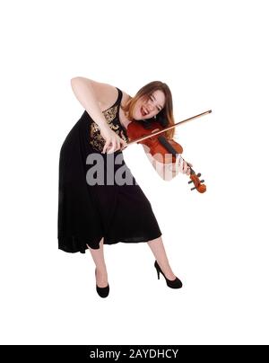 Femme debout dans une robe longue jouant à la flexion de violon Banque D'Images