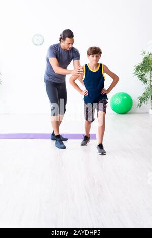 Jeune père de famille et son fils faisant des exercices Banque D'Images