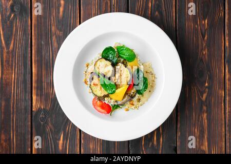 Vue de dessus de l'aubergine rôtie au poivron, au sarrasin vert, à l'écrou de pin et aux graines de citrouille Banque D'Images