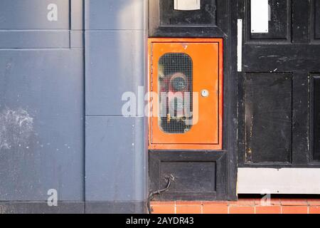 Boîte d'entrée de la rehausse sèche rouge sur le mur de brique pour les services d'incendie d'urgence raccord d'eau pour le moteur de brigade de tuyaux à la porte d'entrée de la maison Banque D'Images