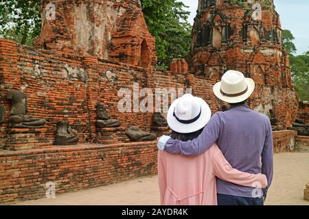 Couple Touristique En Admirant Un Groupe D'Images De Bouddha Sans Tête Reste Dans L'Ancien Temple De Wat Mahatha Dans Le Parc Historique D'Ayutthaya, Ayutthaya, Thaïlande Banque D'Images