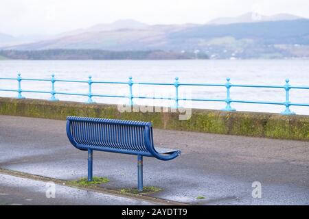 Banc vide isolé dans un espace tranquille de l'esplanade ouverte sur la côte ouest écossaise de la ville de Greenock Banque D'Images