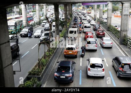 Mandaluyong City, Philippines - 13 février 2020: Les véhicules privés et publics passent le long d'une route principale encombrée de trafic dans le métro de Manille. Banque D'Images