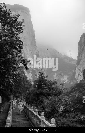 Touristes sur des marches sur le sentier de montagne dans la montagne de Huashan Banque D'Images