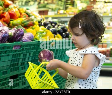 Des aubergines pour les enfants au supermarché. Concept d'achat de fruits et légumes dans l'hypermarché Banque D'Images