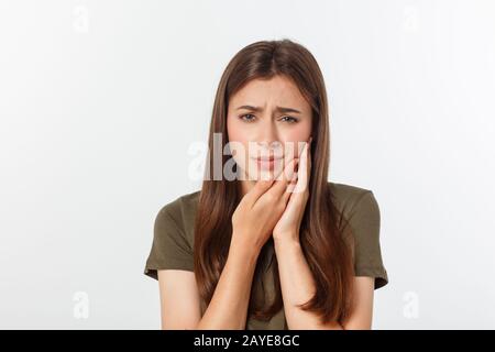 Femme de l'adolescence en appuyant sur sa joue meurtrie avec une expression douloureuse comme si elle a un mal de dent terrible Banque D'Images