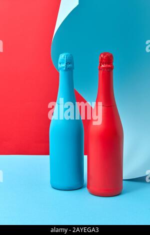Bouteilles de vin maquette peinte en rouge et bleu sur un fond maudié. Banque D'Images