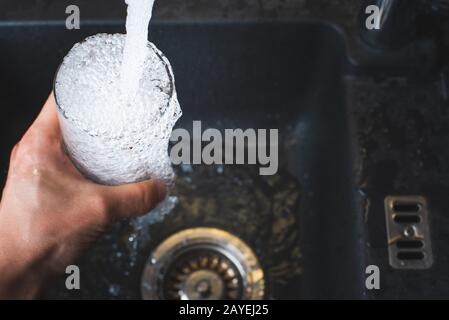 Le remplissage de l'eau de robinet de cuisine en acier inoxydable. Concept de l'eau potable Banque D'Images