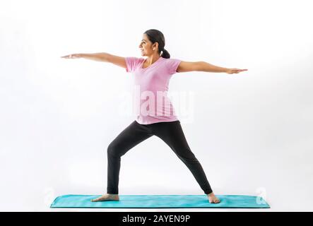 Femme enceinte pratiquant le yoga en position de guerrier. Banque D'Images