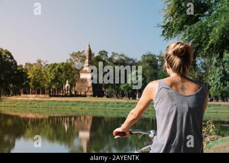 Jeune femme blonde qui monte une architecture à vélo dans la nature, à Sukhotai Thaïlande Banque D'Images