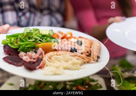 Faites une photo du détail d'une assiette de salade avec crevettes, thon, tomates et betterave dans un restaurant en libre-service Banque D'Images