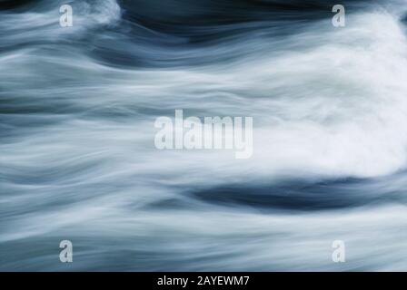 L'obturation lente a créé un résumé de l'eau de rivière en mouvement rapide. Banque D'Images