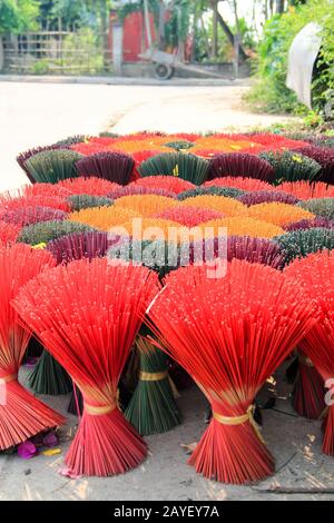 Bouquets de bâtons d'encens colorés placés pour se sécher au soleil à Hoi An, au Vietnam Banque D'Images